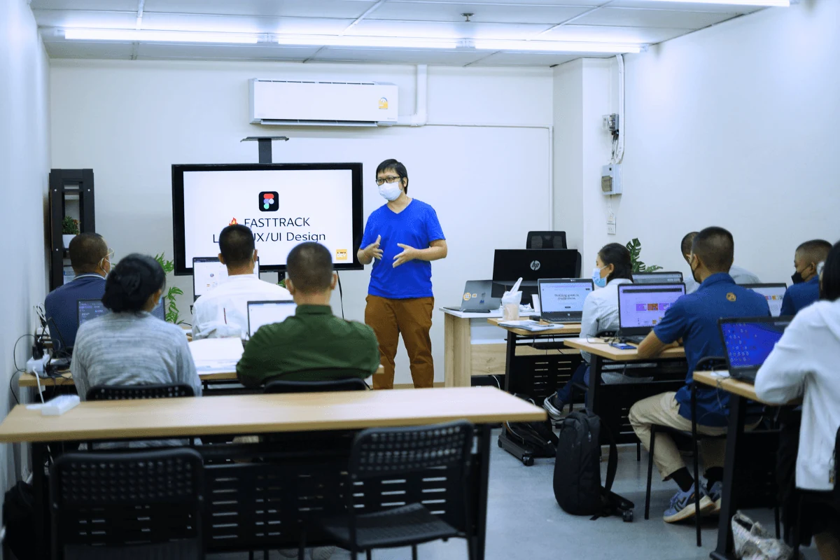 บรรยากาศ Workshop UX/UI ในห้องอบรม ผู้เรียนฝึกทำงานด้วยโน้ตบุ๊กพร้อมผู้สอน